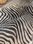 Large cowhide zebra printed faux leather rug in black and beige with unique characteristics by angus oliver
