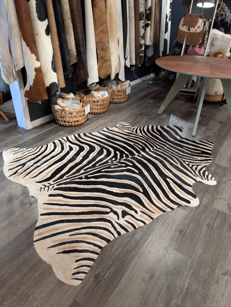 Large cowhide zebra print rug with bold black and beige stripes showcasing unique characteristics by angus oliver