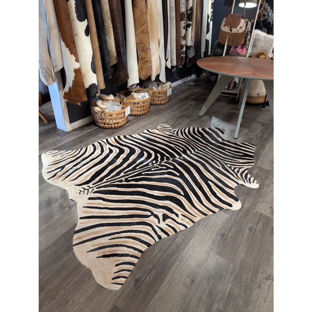 Large cowhide zebra print rug with bold black and beige stripes showcasing unique characteristics by angus oliver