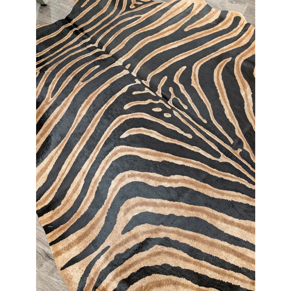 A large cowhide rug with black and tan zebra stripes and soft texture showcasing unique characteristics by angus oliver