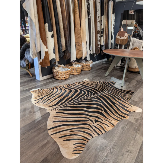 Large cowhide zebra printed rug with bold black and tan stripes on wooden floor showcasing unique characteristics angus oliver