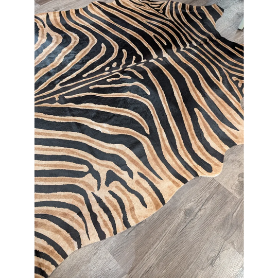 A large cowhide rug from angus oliver with bold black and tan zebra print and soft textured surface showing unique characteristics