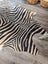 Large cowhide zebra printed faux leather rug in black and cream with unique characteristics by angus oliver